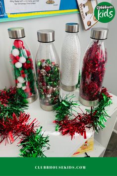 three glass bottles filled with candy and christmas decorations