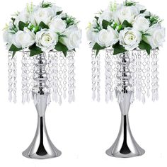 two silver vases with white flowers and chains hanging from the sides, one holding roses