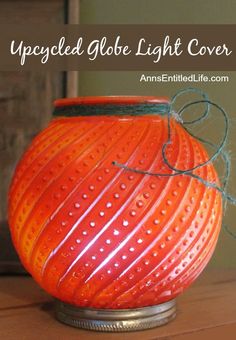 an orange vase sitting on top of a wooden table