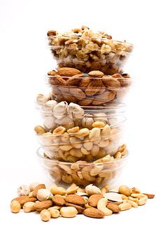 several bowls filled with nuts on top of each other in front of a white background