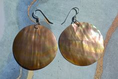 These beautiful earrings feature a carved disc brown mother of pearl shell. . The iridescence of the Mother of Pearl Shell l is really amazing. Depending on the light source they will radiate colors varying from browns to pinks . The shells are then polished to a high gloss to reveal the beauty of their natural pattern. Enjoy these lightweight beauties that are so easy to wear.These beach earrings are perfect for everyday and any occasion. DETAILS - Shell types :Brown Mother of Pearl Shell - Mat Mother Of Pearl Earrings With High Luster For Gifts, Handmade Mother Of Pearl Round Pearl Earrings, Handmade Round Mother Of Pearl Earrings, Nickel Free Iridescent Mother Of Pearl Earrings, Iridescent Mother Of Pearl Drop Earrings, Iridescent Nickel-free Mother Of Pearl Earrings, Nickel-free Iridescent Mother Of Pearl Earrings, Iridescent Mother Of Pearl Earrings, Handmade Mother Of Pearl Earrings