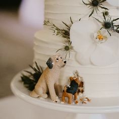 a wedding cake with figurines of dogs on it