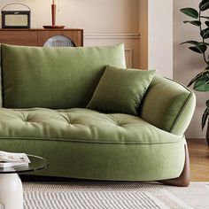 a living room with a green couch and lamp on the side table in front of it