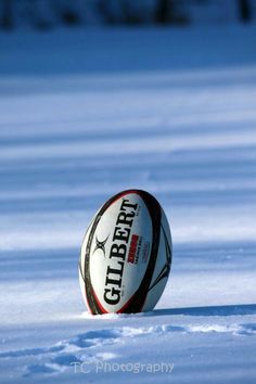 a rugby ball laying in the snow