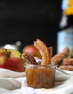 an apple pie in a glass jar with some pretzels sticking out of it