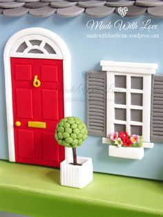 a red door is next to a window and potted plant