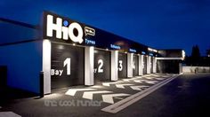 an empty parking lot at night with lit up signs on the building's doors