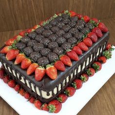 a triple layer chocolate cake with strawberries on top