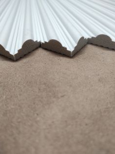 the bottom half of a white corrugated roofing sheet on top of a brown floor