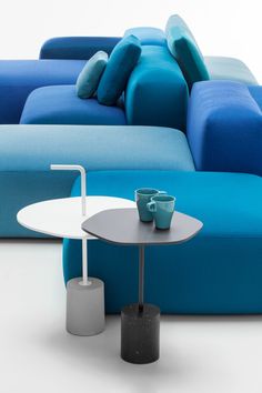 a blue couch and table with two cups on it