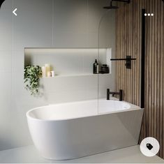 a white bath tub sitting next to a wooden wall