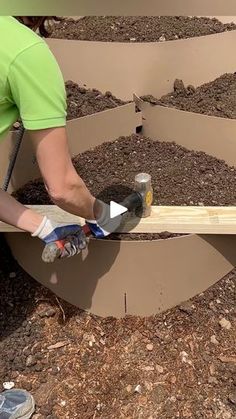 a man is working on some kind of planter box with wood planks in it