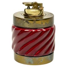 a red and gold canister sitting on top of a white surface