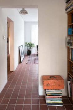 a hallway with bookshelves and tiled flooring