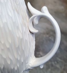 a white vase sitting on top of a table