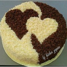 a cake with white and brown frosting in the shape of a heart