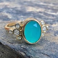 The most insane turquoise blue glow emits from this incredible Peruvian Opal. Set in 14k yellow gold with Emily's signature seagrass band, it is accented with 8 brilliant cut white diamonds. ﻿Approx stone size: 10mm x 8mm Approx stone weight: 1cts Mohs Hardness: 5-6 This one of a kind piece is handmade to order in Emily's Hudson Valley studio. This piece is in stock and currently a size 6.5 but can be resized prior to shipping. If you have questions about sizing, shipping or custom orders please Turquoise 14k Gold Jewelry With Bezel Setting, 14k Gold Turquoise Jewelry With Accent Stones, Anniversary Yellow Gold Chrysoprase Jewelry, Blue Glow, Peruvian Opal, Diamonds Ring, Local Jewelry, Australian Opal, Hudson Valley