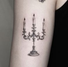 a woman's arm with three candles on it