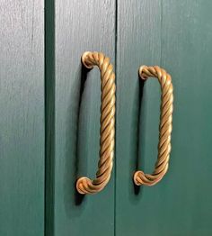 a green door with two rope handles on it