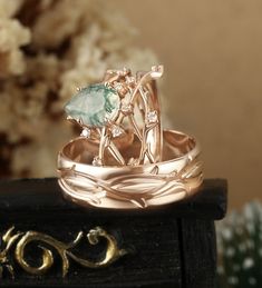 two wedding rings sitting on top of each other with an aqua stone in the center