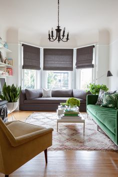 a living room filled with furniture and a chandelier hanging from the ceiling,