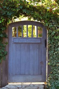 an old wooden gate surrounded by greenery