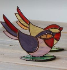 a colorful bird sitting on top of a wooden table