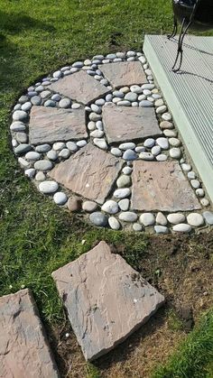 a circular stone path in the grass next to a bench