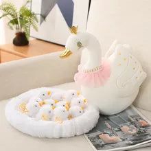 a white swan shaped object sitting on top of a table next to a magazine and potted plant