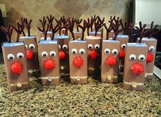 some brown paper bags with red pom - poms and reindeer noses on them