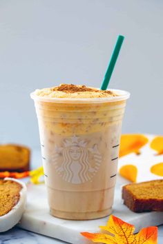 a cup of iced coffee next to some slices of bread and an orange maple leaf