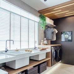 a washer and dryer in a room with wooden shelves on either side of the sink