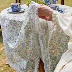 a table with grapes and tea cups on it