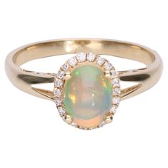 Decorate yourself in elegance with this Ring is crafted from 14-karat Yellow Gold by Gin & Grace. This Ring is made up of Oval-Cab (1 pcs) 0.89 carat Ethiopian Opal and Round-cut White Diamond (22 Pcs) 0.11 carat. This Ring is weight 2.34 grams. This delicate ring is polished to a high finish shine. Gold Ethiopian Opal Ring With Oval Cabochon, Elegant Ethiopian Opal Ring In Oval Cabochon, Unique Ethiopian Opal Cabochon Rings, Cabochon Yellow Gold Opal Ring Collectible, Opal Diamond Ring, Elegant Ethiopian Opal Ring, Oval Cabochon, Ladies Diamond Rings, Delicate Rings, Jewelry Rings Engagement