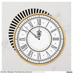 a white and gold clock with roman numerals on the face is seen in this image