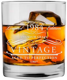 an old fashioned glass with ice cubes in it and the words vintage aged to perfection