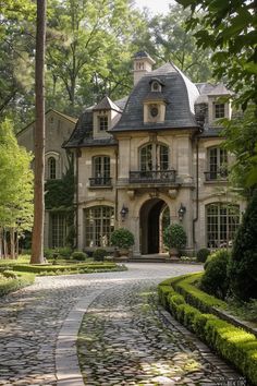 a large stone house surrounded by trees and bushes