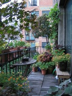 an outdoor balcony with potted plants and benches