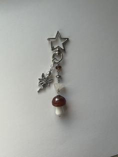 a keychain with a star and mushroom charm hanging from it's side