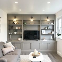 a living room filled with furniture and a flat screen tv on top of a wall