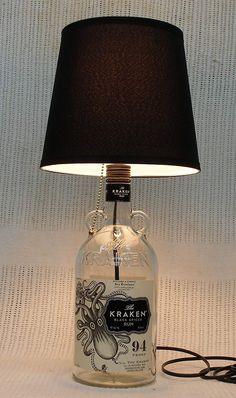 a lamp that is sitting on top of a table next to a bottle with an octopus on it