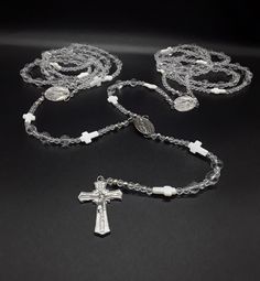 The Silver Wedding Lasso Rosary is an exclusive, special and unique Rosary designed for the special moment in your life. Created for the couple that wishes for a high class wedding lasso Rosary.  In regards to the beads. The beads are made of triple-A high quality Natural Quartz Crystal Beads; completely cleansed and purified. Second, its crosses: there are two types of crosses. The smaller ones that appear along the lasso rosary and are made of the famous Fildisi. The large cross is made of pur Silver Jewelry With 8mm Beads For First Communion, Silver Wedding Rosary With 8mm Beads, Silver Wedding Rosary With Round Beads, Handmade Silver Wedding Rosary, Silver Necklaces With 8mm Beads For Wedding, Silver 8mm Beads Necklaces For Wedding, Silver Spiritual Jewelry For First Communion, Spiritual Silver Jewelry For First Communion, Silver Spiritual Wedding Rosary