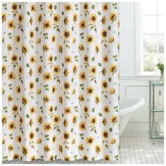 a shower curtain with sunflowers on it in front of a bathtub and window