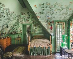 a bedroom with floral wallpaper and green painted walls, along with an antique bed