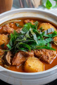 a white bowl filled with meat and vegetables