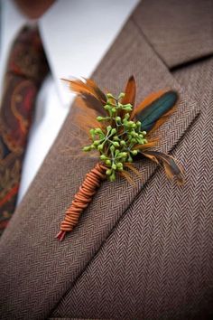 a man wearing a suit and tie with a boutonniere on his lapel