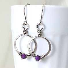 Eco friendly sterling silver (16G) has been hand formed and hammered into hoops. An organic spiral has been wire wrapped around a 4mm purple fossil stone bead. The hoops have been oxidized and lightly brushed with steel wool and then polished for a soft patina. Perfect earrings for the holidays! Ear wires are hand formed from sterling silver. Earrings measure 1.75 inches from top of ear wire to bottom of teardrop. The widthr at widest part is 7/8 of an inch. All silver used has come from a recyc Ear Art, Earrings Wire, Wrapped Earrings, Earrings Purple, Eco Friendly Jewelry, Wire Wrapped Earrings, Wire Earrings, Copper Earrings, Earrings Etsy