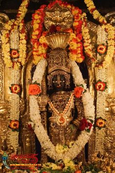 the statue is decorated with flowers and garlands