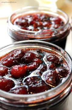 two jars filled with jam sitting on top of a table