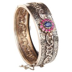 Russian Imperial period fine bangle in 84 Silver. Main attraction here is a Flower measuring 17 mm x 14 mm with natural and untreated medium Blue colored Sapphire 8 mm x 6.5 mm x 5 mm ca.2 ct surrounded with 12 baguette cut Rubies 2.25 mm x 2 mm /0.045 ct / ca 0.45 ctw. Ornamental divided Black Enameling work and stamped ornamentations. This bangle dates to ca. late XIX - early XX century. Hallmarked with Imperial period Russian 84 zolotniks silver marks used in late XIX early XX century before Russian Jewelry, Old Rings, Photo Equipment, Jewelry Workshop, Main Attraction, Old Jewelry, Silver Bangle Bracelets, Nature Bracelets, Silver Bangles